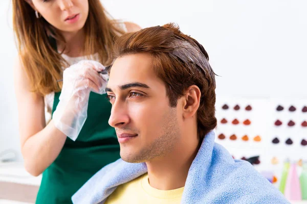 Peluquero mujer aplicando tinte al cabello del hombre —  Fotos de Stock