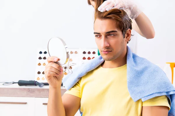 Cabeleireiro mulher aplicando tintura para o cabelo do homem — Fotografia de Stock