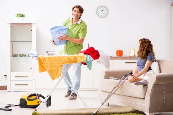 Make att hjälpa Ben skadade hustru i hushållsarbete — Stockfoto