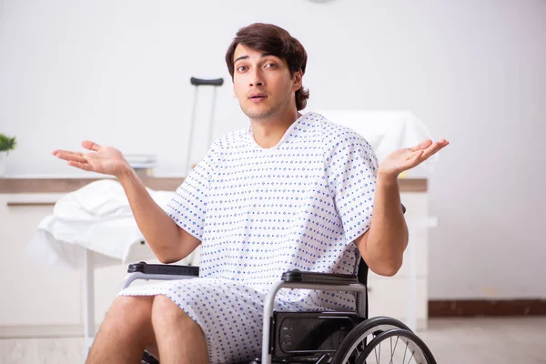 Joven hombre guapo en silla de ruedas en el hospital —  Fotos de Stock