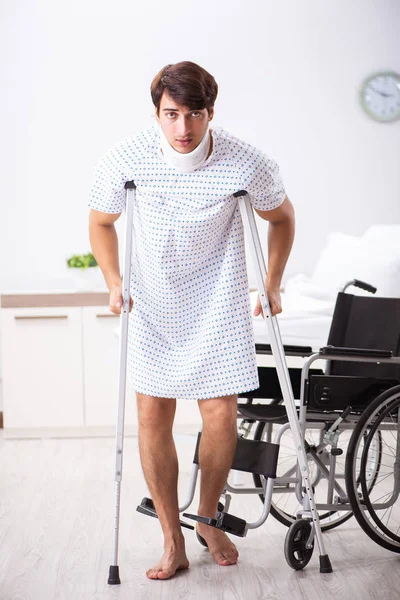 Junger schöner Mann im Rollstuhl im Krankenhaus — Stockfoto