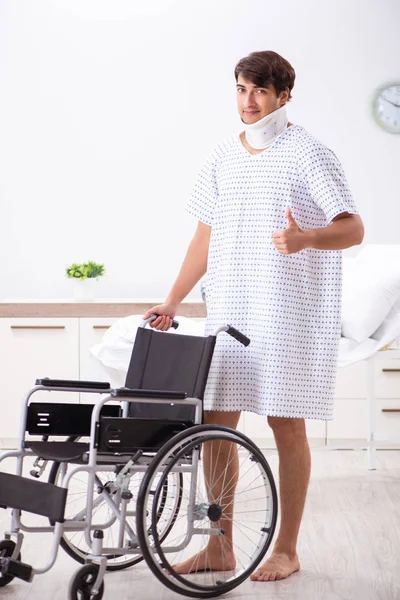 Junger schöner Mann im Rollstuhl im Krankenhaus — Stockfoto