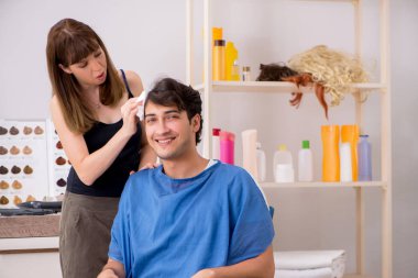 Genç çekici adam bayan berberi ziyaret ediyor. 