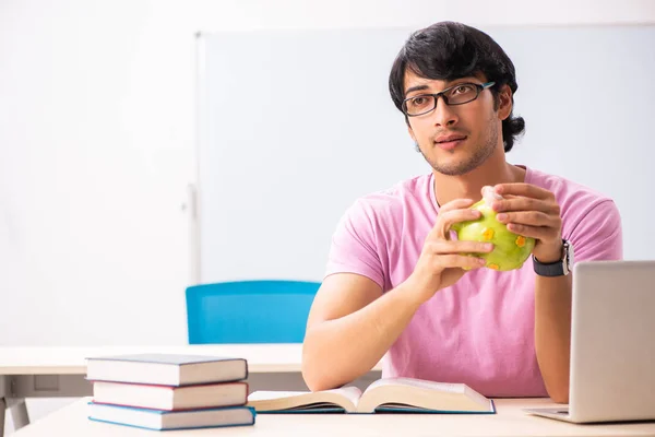 Joven estudiante masculino sentado en la clase — Foto de Stock