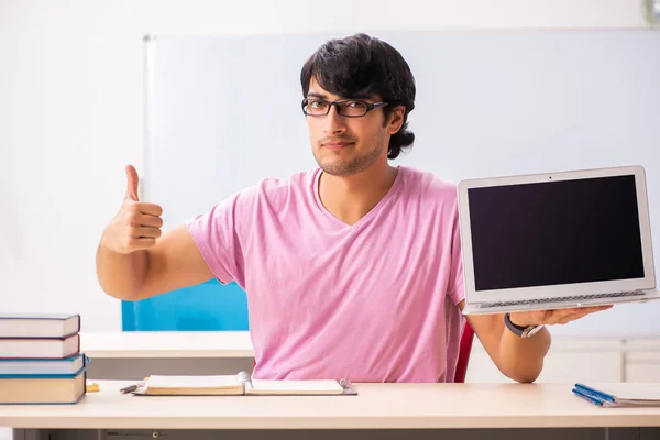 Giovane studente maschio seduto in classe — Foto Stock