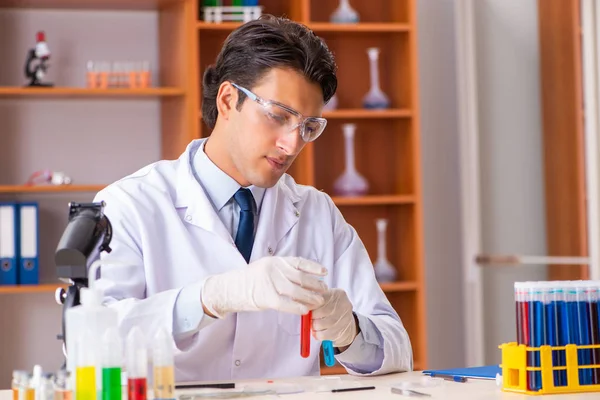 Joven bioquímico guapo trabajando en el laboratorio — Foto de Stock