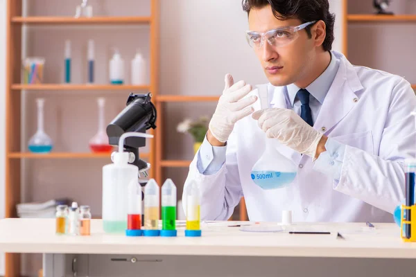 Giovane bel biochimico che lavora in laboratorio — Foto Stock