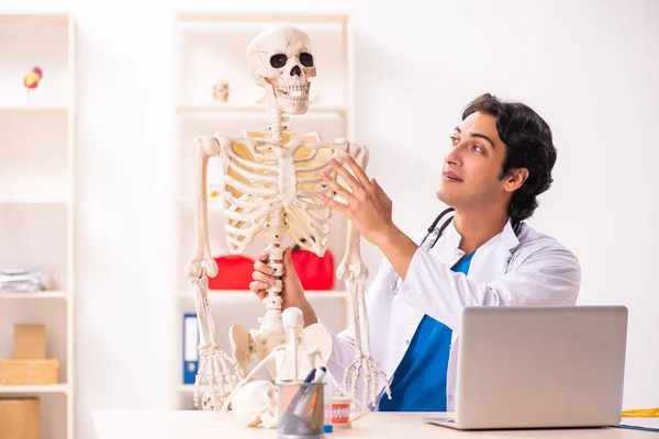 Young male doctor with skeleton — Stock Photo, Image