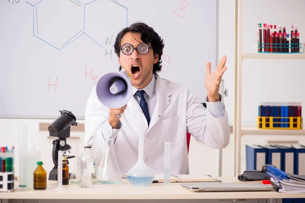 Young funny chemist in front of white board — Stock Photo, Image
