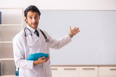 Genç doktor beyaz tahtanın önünde. 