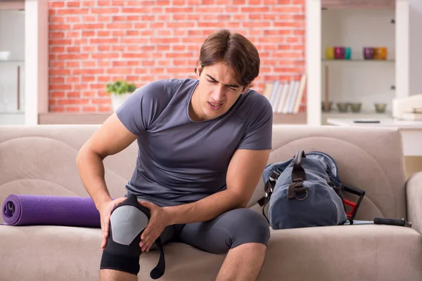 Jovem homem bonito fazendo exercícios esportivos em casa — Fotografia de Stock