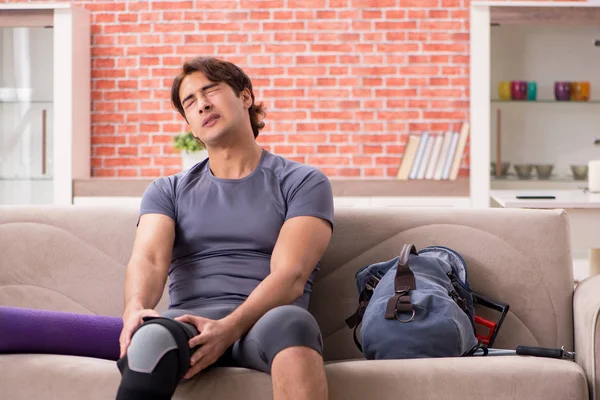 Joven hombre guapo haciendo ejercicios deportivos en casa — Foto de Stock