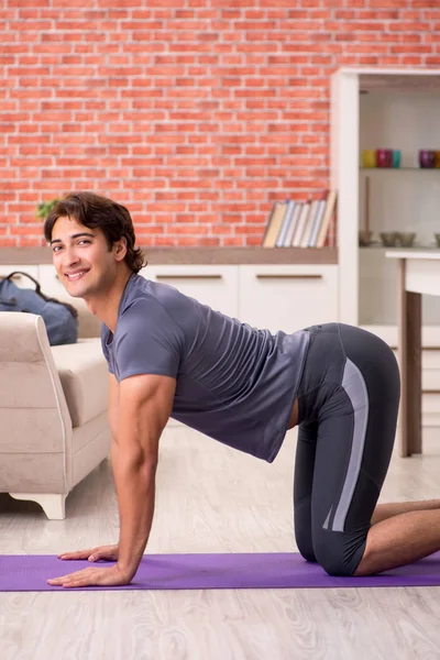 Mladý pohledný muž dělá sportovní cvičení doma — Stock fotografie