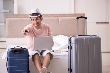 Bavul seyahat için bekleyen yatak odasında olan adam 