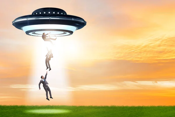Flying saucer abducting young businessman — Stock Photo, Image
