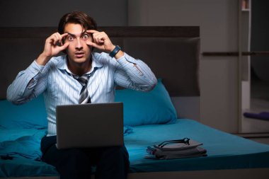 Yorgun işadamı gece fazla mesai yapıyor.
