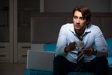 Yorgun işadamı gece fazla mesai yapıyor.