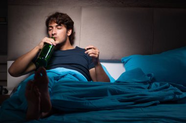 Stres altında yatakta içme adam