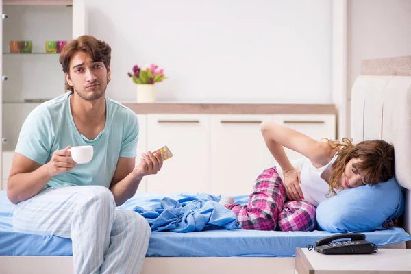Ung man söker efter sjuka hustru i sovrummet — Stockfoto