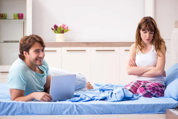 Young couple with laptop in the bedroom — Stock Photo, Image