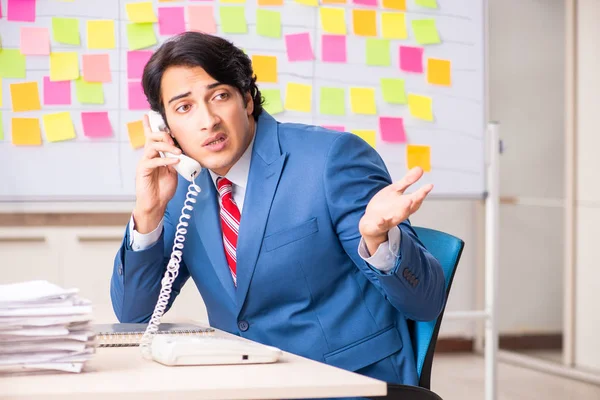 Young handsome employee with many conflicting priorities — Stock Photo, Image