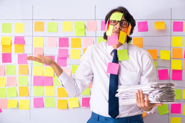 Jonge werknemer in tegenstrijdig prioriteitsconcept — Stockfoto