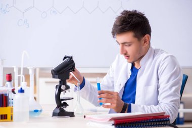 Laboratuarda oturan genç kimyager 