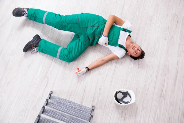 Joven trabajador cayendo de la escalera — Foto de Stock