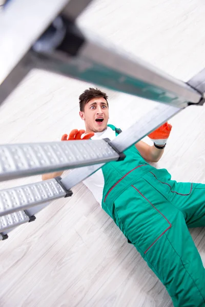 Unga arbetstagare faller från stegen — Stockfoto
