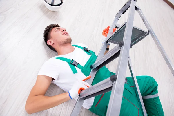 Молодой рабочий падает с лестницы — стоковое фото