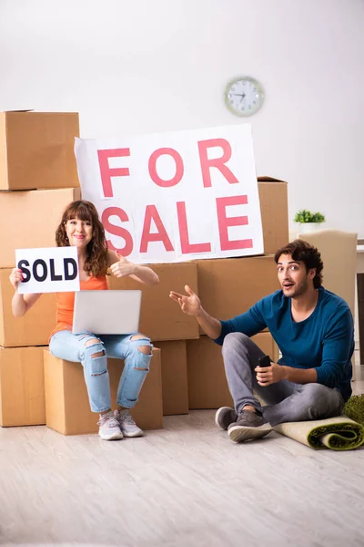 Joven familia ofreciendo casa para la venta y mudanza — Foto de Stock