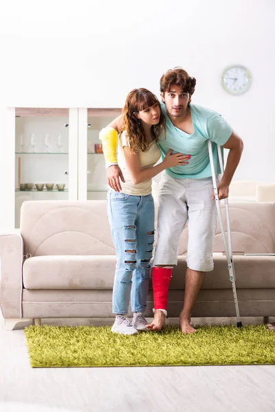 Familia joven ayudándose mutuamente después de una lesión —  Fotos de Stock