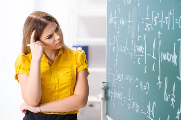 Ung kvinnlig student framför tavlan — Stockfoto