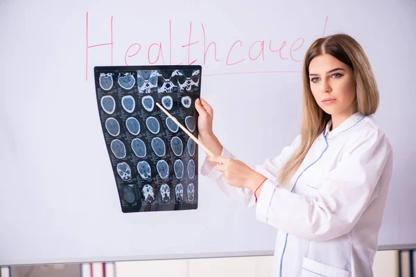 Jonge vrouwelijke arts voor het witte bord — Stockfoto