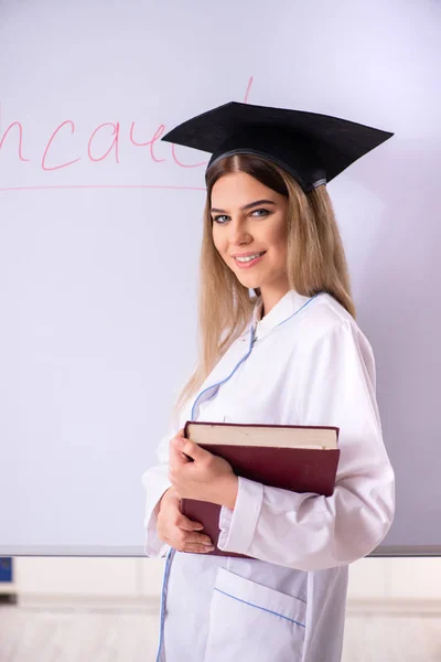 Doctora joven de pie frente a la pizarra blanca —  Fotos de Stock