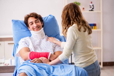 Hastanede yaralı kocayla ilgilenen sevgili bir eş. 