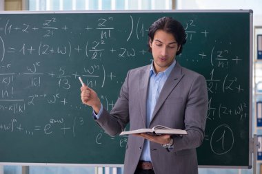 Genç yakışıklı matematik öğretmeni sınıfta 