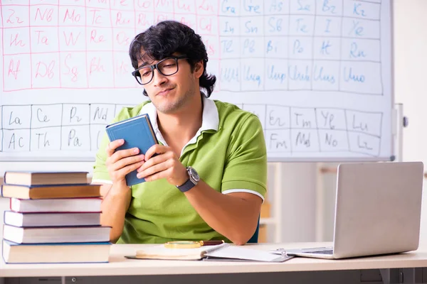 Ung manlig student kemist framför periodiska systemet — Stockfoto