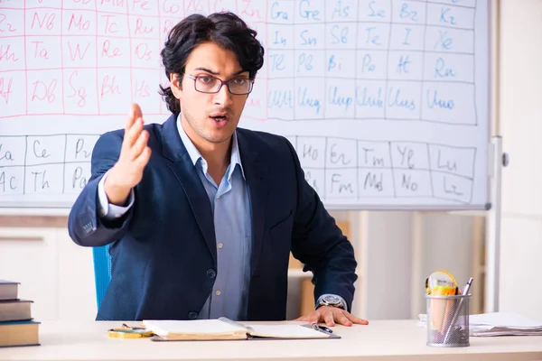 Joven profesor de química masculino delante de la tabla periódica —  Fotos de Stock