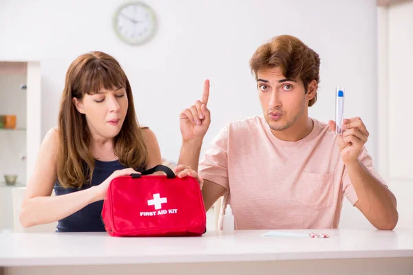 Young family getting treatment with first aid kit — Stock Photo, Image