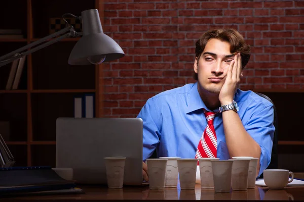 Young employee drinking coffee working at night shift — Stock Photo, Image