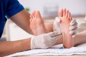 Podologe behandelt Füße während des Eingriffs