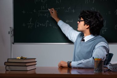 Kara tahta önünde genç matematik öğretmeni