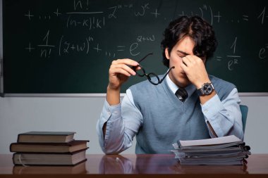Kara tahta önünde genç matematik öğretmeni