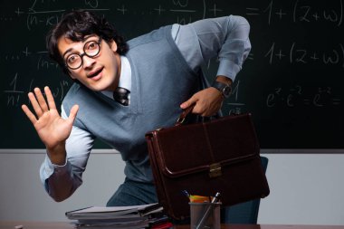 Kara tahta önünde genç matematik öğretmeni