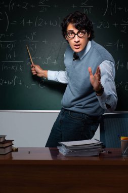 Kara tahta önünde genç matematik öğretmeni