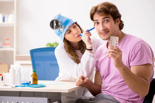 Jovem bonito homem visitando jovem médico otorrinolaringologista — Fotografia de Stock