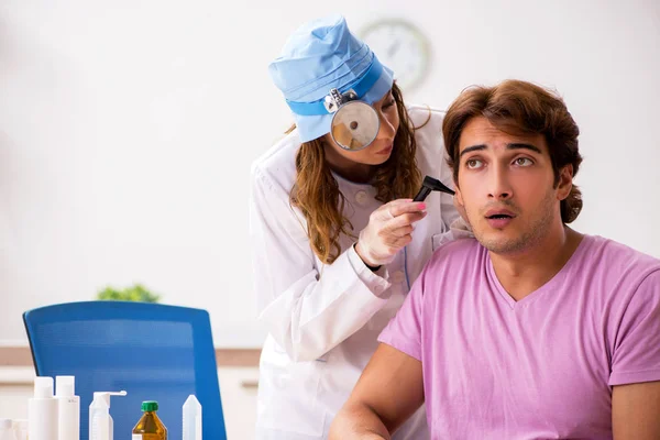 Ung vacker man besöker unga kvinnliga läkare otolaryngologist — Stockfoto