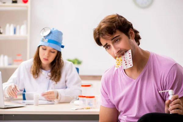 Ung vacker man besöker unga kvinnliga läkare otolaryngologist — Stockfoto