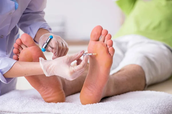 Podólogo tratando los pies durante el procedimiento — Foto de Stock